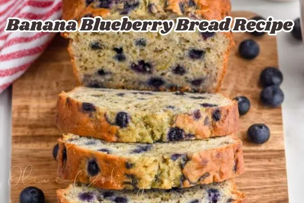 Sliced banana blueberry bread on a wooden board, showing a moist, golden loaf filled with juicy blueberries. A few fresh blueberries are scattered around, and a red-striped towel is visible in the corner. The image features the text "Banana Blueberry Bread Recipe" across the top.