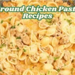A skillet filled with orecchiette pasta and ground chicken in a creamy tomato sauce, topped with melted parmesan cheese and garnished with chopped parsley.